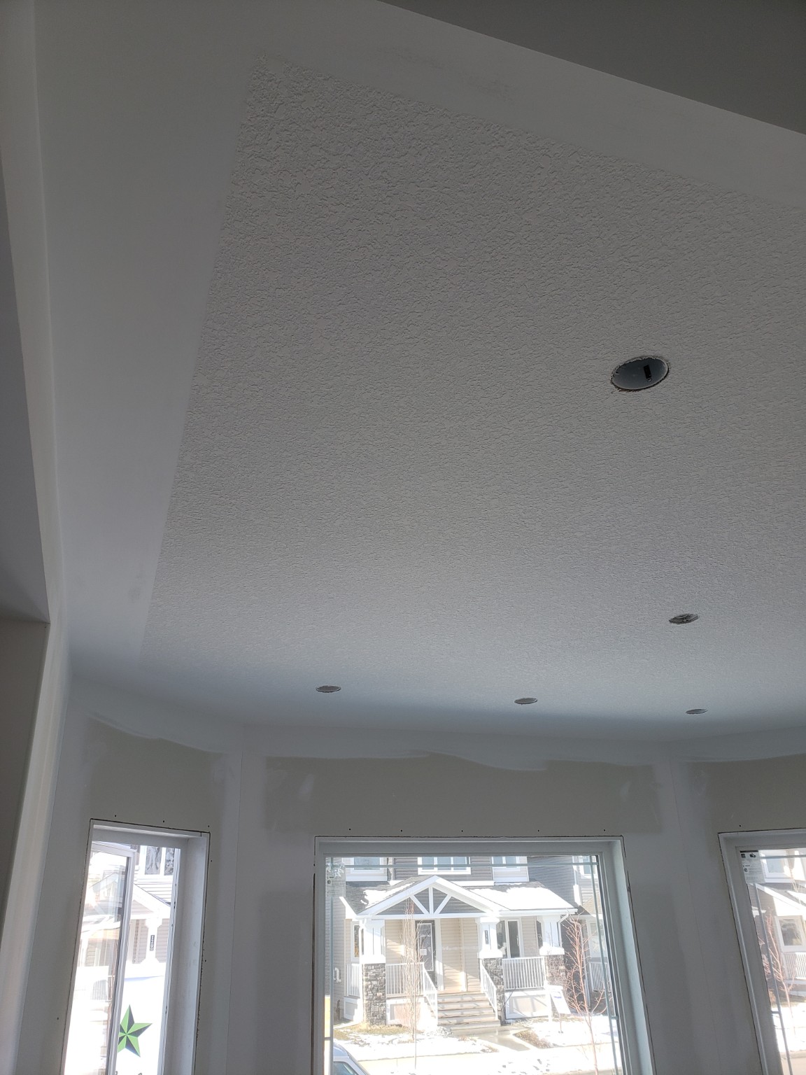 Textured ceiling with smooth border and recessed light openings